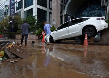 BANYAK kereta rosak akibat tenggelam dalam banjir selepas hujan lebat di daerah Gangnam, Seoul.-AFP