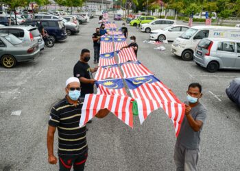 PENDUDUK Projek Perumahan Rakyat (PPR) Padang Hiliran menunjukkan Jalur Gemilang sepanjang 50 meter untuk digantung dari tingkat 17 ketika ditemui di Kuala Terengganu, hari ini. - UTUSAN/PUQTRA HAIRRY ROSLI