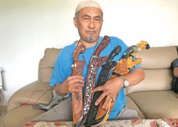 WAN Mohd. Aris Wan Abdullah menunjukkan golok yang dihasilkannya di Kampung Tanah Putih, Gua Musang, Kelantan. 
– UTUSAN/AIMUNI TUAN LAH
