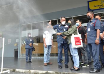 AZMI Osman (kiri) memberi penerangan mengenai penggunaan gegelung hos kepada petugas media pada Kempen Keselamatan Kebakaran Musim Perayaan Tahun Baru Cina 2022 di sebuah pasar raya di Ipoh hari ini. - UTUSAN/ZULFACHRI ZULKIFLI