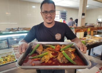 MUHAMAD Rozi Kasim menunjukkan gulai kepala ikan yang menggunakan rempah giling di Restoran Uncle Chen Gulai House, Kota Kuala Muda, Sungai Petani, Kedah. - UTUSAN/NUR SYAZWANA MANSOR