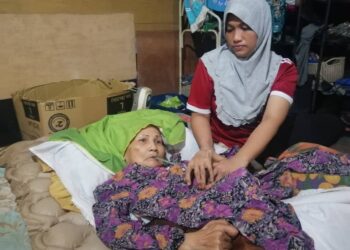 KALSOM Harun yang terlantar akibat diserang angin ahmar dijaga dan diurus oleh Norasila Mohd. Noor di Kampung Pela, Ajil, Hulu Terengganu. - UTUSAN/NOOR HAYATI MAMAT