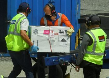PETUGAS mengangkat kotak yang mengandungi vaksin Covid-19 keluaran Pfizer-BioNTech yang tiba di lapangan terbang Jose Maria Cordova, Colombia. - AFP