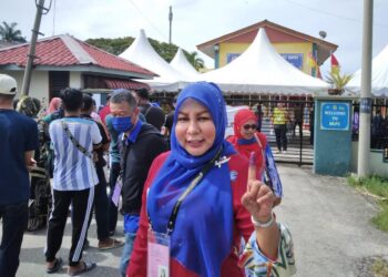 HABIBAH Mohd. Yusof (tengah) menunjukkan jarinya selepas selesai mengundi di SK Parit 4, Tanjong Karang, Kuala Selangor, Selangor.-UTUSAN/ ISKANDAR SHAH MOHAMED