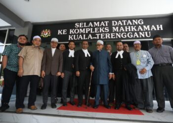 ABDUL Hadi Awang (empat, kanan) bersama barisan peguam dan penyokongnya di Kompleks Mahkamah Kuala Terengganu, Kuala Terengganu, semalam.
