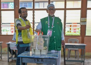 ABDUL Hadi Awang membuang undi di pusat pembuangan undi di SK Rusila, Marang, Terengganu. - UTUSAN/PUQTRA HAIRRY ROSLI