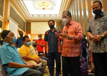 MUHYIDDIN Yassin (dua, dari kanan) diiringi Ahmad Samsuri Mokhtar beramah mesra dengan penerima vaksin Covid-19 di pusat pemberian vaksin (PPV) di Taman Tamadun Islam (TTI) di Kuala Terengganu hari ini. - UTUSAN/PUQTRA HAIRRY ROSLI