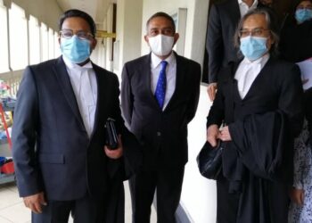 MOHD. Hafarizam Harun (tengah) keluar dari kamar Mahkamah Sesyen Kuala Lumpur semalam.