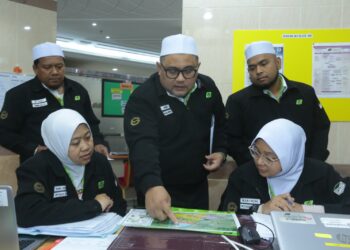 Mohd. Zawawi Bostam (tengah) berbincang dengan petugas-petugas PJH di pejabatnya dekat Abraj Al-Janadriyah, Mekah.