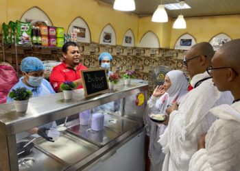 MOHD. Haruji Mohd. Yahya (dua dari kiri) melayan jemaah yang membeli sarapan di Hajj Cafeteria di Abraj Al-Janadriyah di Mekah.