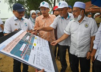 NIK Nazmi Nik Ahmad (dua, kiri) diberi penerangan mengenai Projek Pengawalan Hakisan Pantai di Pantai Tok Jembal, Kuala Nerus, Terengganu, hari ini. - UTUSAN/PUQTRA HAIRRY ROSLI