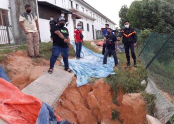 PENDUDUK menunjukkan hakisan tanah yang berlaku di belakang kediaman mereka di Taman Scientex, Pasir Gudang, Johor. - FOTO/KHAIRUL MOHD. ALI