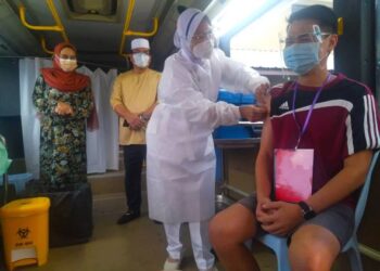 HALIMAH Mohamad Sadique (kiri) dan Sulaiman Md. Ali melihat proses vaksinasi di dalam bas bergerak pada program Movac Japerun Kuala Linggi, Alor Gajah, Melaka. - FOTO/MUHAMMAD SHAHIZAM TAZALI