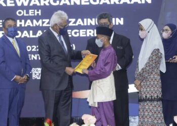 HAMZAH Zainudin menyampaikan surat kewarganegaraan kepada Ahmad Umar Harish Shahrom Abdullah pada Majlis Penyerahan Surat Keputusan Kewarganegaraan di Kompleks D, Putrajaya. - FOTO/FAISOL MUSTAFA