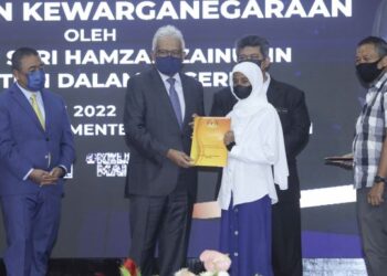 HAMZAH Zainudin menyampaikan surat kewarganegaraan kepada Nur Maisarah Hasinah Abdullah pada Majlis Penyerahan Surat Keputusan Kewarganegaraan di Putrajaya. - FOTO/FAISOL MUSTAFA