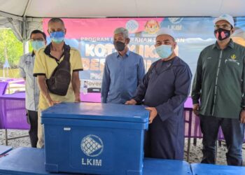 SYED Abu Hussin Hafiz Syed Abdul Fasal (dua dari kanan) menyerahkan kotak ikan berinsulasi kepada nelayan di Jeti Sungai Kelubong di Bukit Gantang, Perak,  hari ini. - UTUSAN/MOHAMAD HAFIZI MOHD. SAID