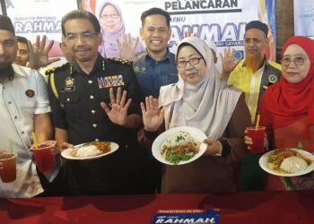 Fuziah Salleh (barisan hadapan, dua kanan) menunjukkan Menu Rahmah yang ditawarkan di Restoran Cahaya Mesra Seafood, Kijal, Kemaman, hari ini. - UTUSAN/NIK NUR IZZATUL HAZWANI NIK ADNAN