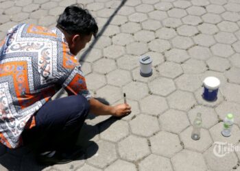 SEORANG lelaki menyusun beberapa objek bagi melihat fenomena hari tanpa bayang di Bandung, Indonesia. - TRIBUNNEWS