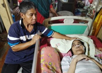 TAHIR Al Tipah (kiri) memegang Faridah Ishak yang dicakar harimau akar di bahagian kening di Kampung Sentang di Lipis, Pahang. - FOTO/HARIS FADILAH AHMAD