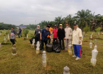 MD. Nayan Salleh (dua dari kiri) dalam program gotong-royong membersihkan tanah perkuburan Islam Kampung Haji Taib, Kuala Kurau hari ini. - UTUSAN/WAT KAMAL ABAS