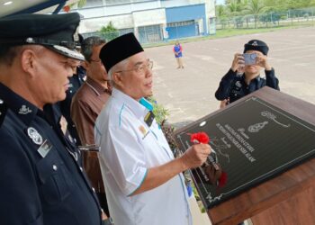 HASSAN ABDUL KARIM menandatangani plak perasmian sambil diperhatikan Mohd. Sohaimi pada Majlis Penyerahan Pentas Utama IPD Seri Alam, Pasir Gudang.