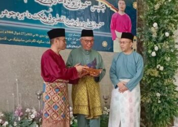 HASSAN Abdul Karim (tengah) menerima cenderahati pada majlis Sambutan Hari Raya Aidilfitri dan Hari Guru Peringkat Daerah Johor Bahru di Sekolah Agama Taman Scientex, Pasir Gudang, Johor, hari ini.