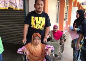 HAWA Murad dibantu Mohamad Zairuddin ketika melaksanakan tanggungjawab mengundi di SK Parit Bakar, Muar, Johor.