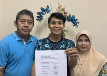 Muhammad Haziq Asyraaf Rosli bersama ibu dan bapanya menunjukkan keputusan 9A dalam SPM 2020 yang keputusannya keluar  hari ini.