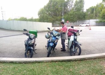 ABU Hanifah Ahmad Ismail bersiap sedia untuk menghantar makanan yang dipesan pelanggannya Seksyen 13, Shah Alam, Selangor. - UTUSAN / MOHAMAD NAUFAL MOHAMAD IDRIS