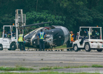 KAKITANGAN LTSAAS mengalihkan badan helikopter yang terhempas di LTSAAS, Subang, semalam. 
– UTUSAN/MUHAMAD IQBAL ROSLI