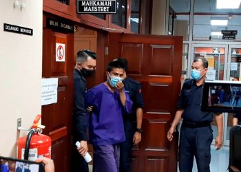 MOHD. Faizal Ramly dibawa keluar dari Mahkamah Majistret Kuala Kangsar atas pertuduhan mencederakan anak perempuannya dalam kejadian Ahad lalu. - UTUSAN/SAYED HESHAM IDRIS