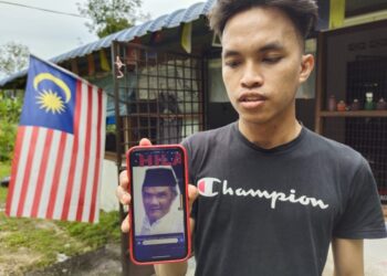 MUHAMMAD Haikal Mohd. Noor menunjukkan gambar terkini bapanya, ketika ditemui di Kampung Batu 1, Pedas, Rembau hari ini.-UTUSAN/NOR AINNA HAMZAH.