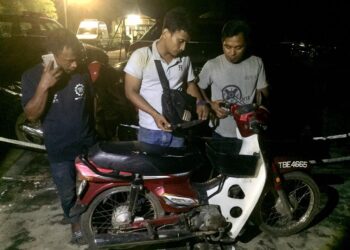 ASHAHIDI Awang (tengah) menunjukkan motosikal milik Mohd. Azani Alias yang ditemukan di kaki Bukit Sudu, Kuala Nerus, semalam. - UTUSAN/PUQTRA HAIRRY ROSLI