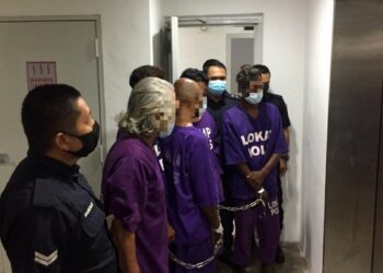 SUSPEK (dua dari kiri) yang dikenakan perintah tahanan reman empat hari bagi membantu siasatan kes menghina agama Islam dibawa keluar dari Mahkamah Majistret Kuala Terengganu, hari ini. - UTUSAN/TENGKU DANISH BAHRI TENGKU YUSOFF