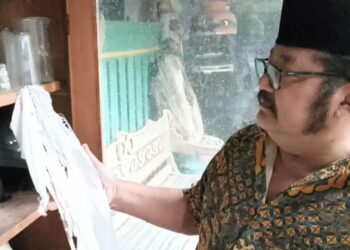 SUTARJI menunjukkan tali kain kafan yang menjadi koleksinya. - AGENSI