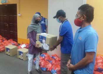ZAMBRY Abd. Kadir (tengah) menyampaikan bantuan barangan keperluan harian kepada wakil pekerja sebuah hotel di Pulau Pangkor, Perak, hari ini.  