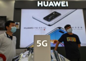DUA lelaki melalui gerai pameran Huawei di China baru-baru ini. Huawei berdepan sekatan lebih ketat oleh Amerika Syarikat. – AFP
