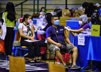 PETUGAS kesihatan memberikan suntikan dos penggalak vaksin Covid-19 kepada orang ramai di Bangkok, Thailand. - AFP