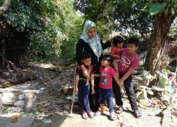 NUR HAJAR Salim yang kudung sebelah anggota kaki bersama-sama anaknya di rumah mereka di Kampung Sulup, Teluk Kumbar, Pulau Pinang. - UTUSAN/NOOR HASLIZA NUSI