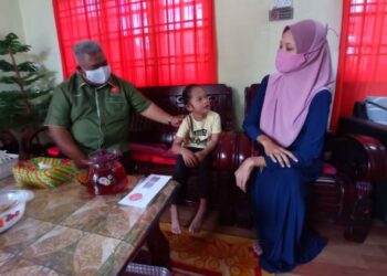 YUSLIZA Md. Yunos (kanan) bersama anaknya, Nur Batrisyia Mokhtar ketika menerima kunjungan, Nasaruddin Ahmad (kiri) bagi menyerahkan bantuan wang tunai di Felda Air Tawar 2, Kota Tinggi, Johor. - FOTO/MASTURAH SURADI
