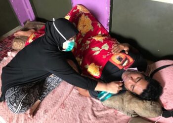 ESHAH Samat memberi minuman kepada suaminya, Jamal Abdilah di rumah mereka di Taman Agropolitan Rantau Manis, Gua Musang, Kelantan. - UTUSAN/AIMUNI TUAN LAH