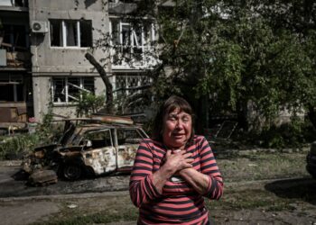 SEORANG wanita tidak dapat menahan kesedihan di luar apartmen yang didiaminya di Donbas.-AFP
