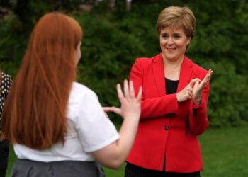 MENTERI Pertama Scotland, Nicola Sturgeon menunjukkan cara berkomunikasi menggunakan bahasa isyarat semasa mengadakan lawatan di Sekolah Rendah Castleton, Glasgow.-AFP