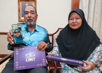 KAMARUDDIN Najib dan Azizah Osman menunjukkan skrol serta gambar Allahyarham Fatin Nabila pada majlis Konvokesyen UMT Ke-20 di Kuala Nerus, Terengganu, hari ini. - UTUSAN/KAMALIZA KAMARUDDIN