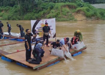 MOHD. SOFFI Abd. Razak (depan, dua dari kanan) bersama Abdullah Jaafar (kanan) melepaskan ikan Lampam Sungai dan Kelah di jeti Sungai Lipis berdekatan Kampung Melayu Benta di Lipis, Pahang. - UTUSAN/HARIS FADILAH AHMAD