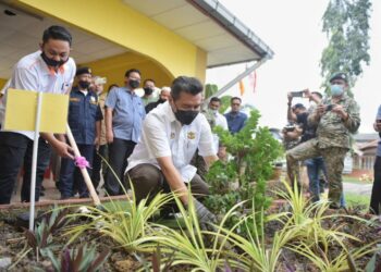 IKMAL Hisham Abdul Aziz menanam pokok bonsai sebagai simbolik pelancaran Program Jiwa Murni Tentera bersama Warga Felda Kemahang, Kemahang 1, Tanah Merah hari ini. - UTUSAN/BAHRUDDIN HATTA