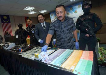 RUSLIN Jusoh menunjukkan antara barang rampasan dalam sidang akhbar sindiket perjudian didalangi warga asing di Jabatan Imigrsen Putrajaya. - UTUSAN/FAISOL MUSTAFA