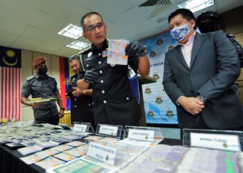 KHAIRUL Dzaimee Daud menunjukkan pasport yang dirampas dalam sindiket membekalkan tenaga kerja dan PLKS palsu di Jabatan Imigresen, Putrajaya. - UTUSAN/FAISOL MUSTAFA
