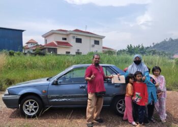 DIZI YARNA Muhammad bersama empat anaknya menerima kunci dan geran kereta daripada 
Shikh Muhammad Makhdad Haron. - UTUSAN/DIYANATUL ATIQAH ZAKARYA