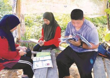 BEBERAPA orang pelajar sedang mendapatkan capaian internet di sebuah pondok yang berada di puncak bukit di Kampung Mambong, Kuala Krai, Kelantan.UTUSAN/ KAMARUL BISMI KAMARUZAMAN